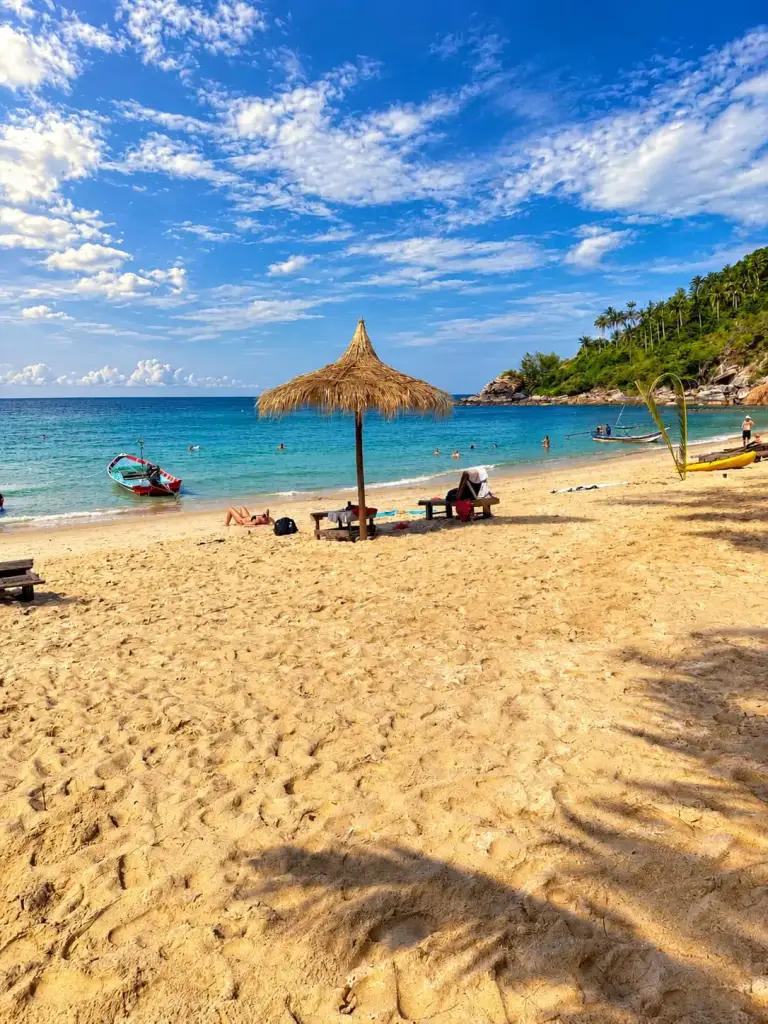 שמשיית קש ומבקרים על החוף ב-Bottle Beach