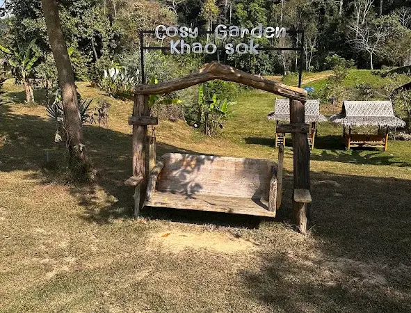 נדנדת עץ ושלט Cosy Garden Khao Sok, וצוקי גיר ברקע