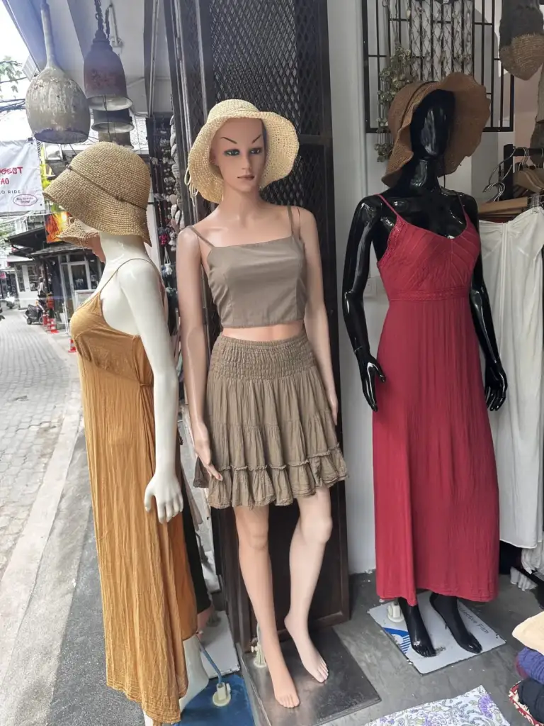 שמלות כותנה, טופ וחצאית וכובעי קש בחנות בגדי חוף בקופנגן